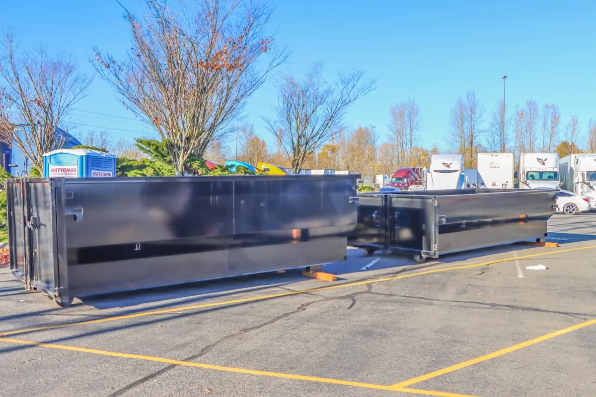 Professional dumpster rental service with roll-off container on residential driveway in Hopkins